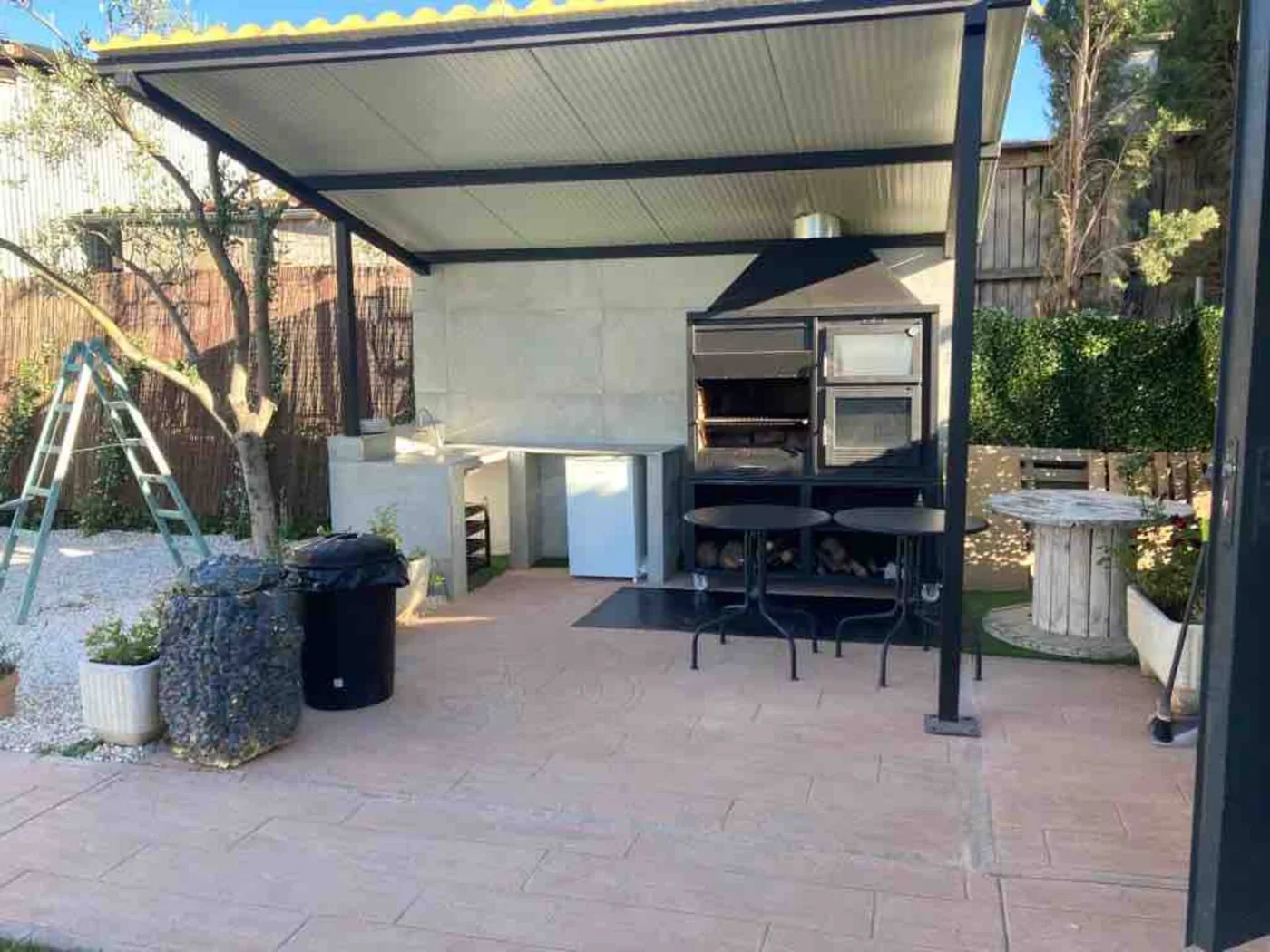 Cocina exterior con barbacoa bajo techo