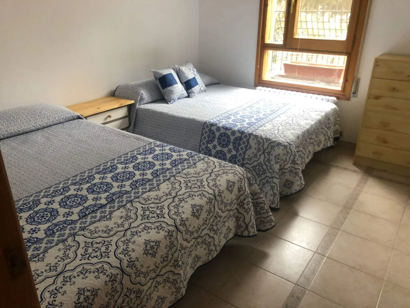 Dormitorio con dos camas y colchas azules