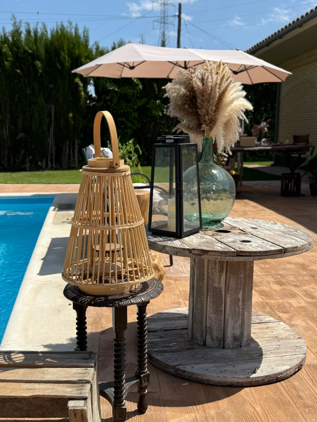 Decoración con farol y jarrón junto a la piscina