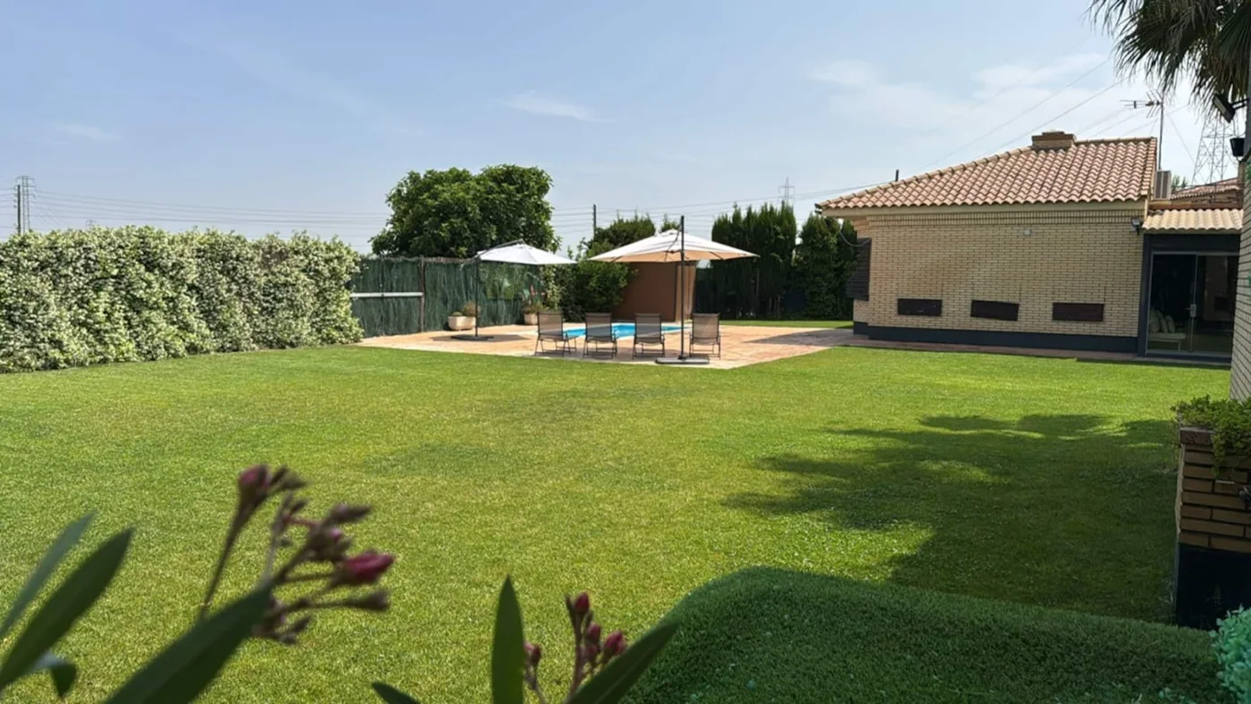 Gran jardín de césped con la casa al fondo