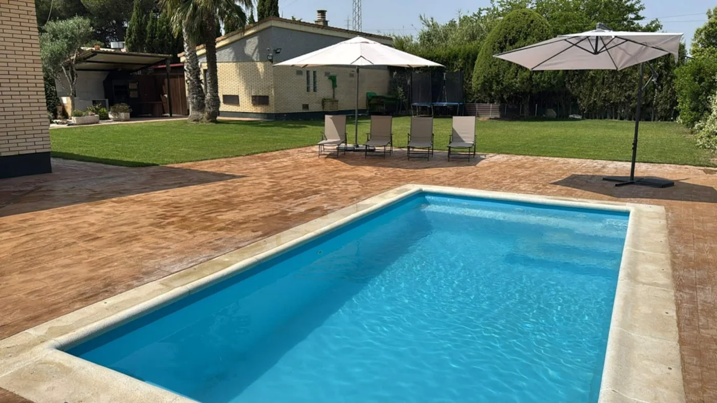 Piscina con sombrillas y tumbonas