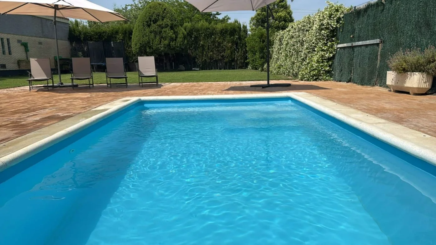 Piscina privada con tumbonas al fondo