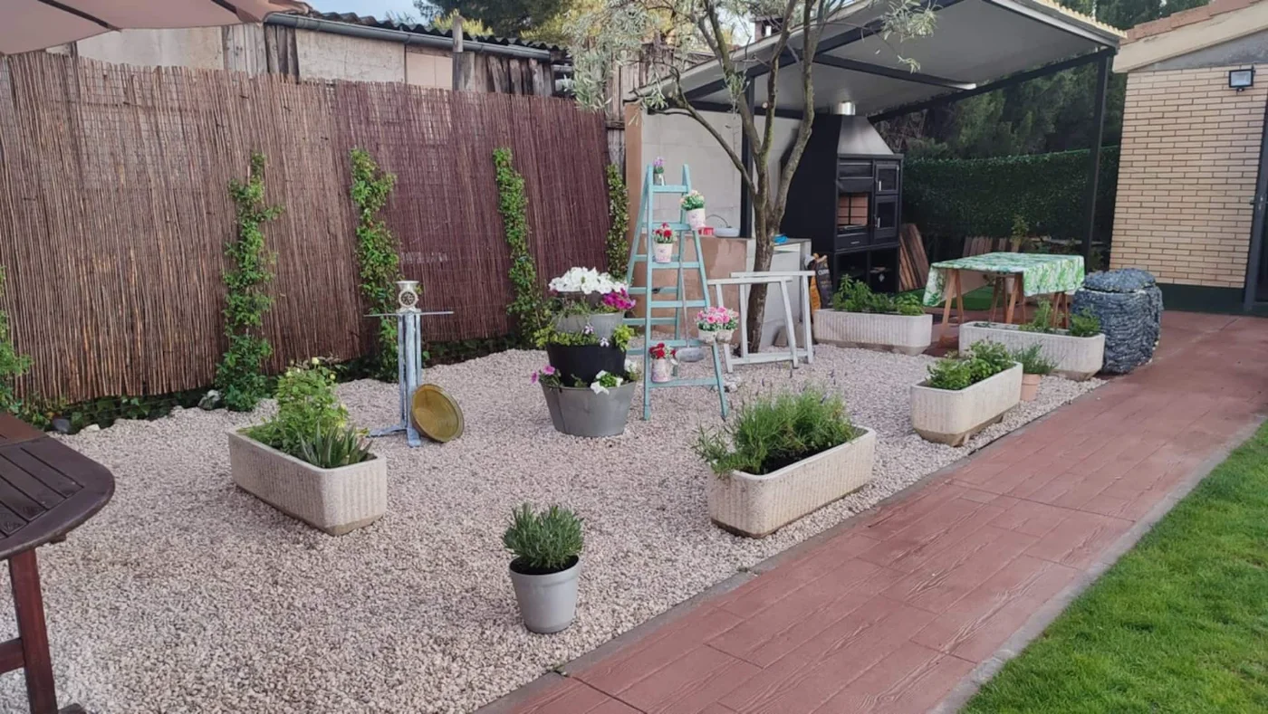 Rincón de grava con jardineras y flores
